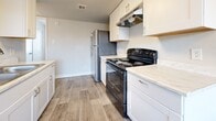 Located at 4235 N 35th Ave in Phoenix, Arizona, this single-floor unit offers a practical and well-appointed layout across three bedrooms, two kitchen areas, and a welcoming entrance. Wood-look plank flooring runs consistently throughout the space, lending a clean, cohesive aesthetic to every room.

The bedrooms are comfortably sized, with the primary bedroom offering generous proportions. Each bedroom features ceiling fans with light fixtures, ample closet space with bifold doors, and windows fitted with blinds that bring in natural light. The neutral gray and white color palette gives each room a bright, airy feel.

The kitchen is efficiently designed with white cabinetry, light stone-look countertops, a black electric range, and a full-size refrigerator. An under-cabinet range hood and overhead ventilation round out the functional cooking space. The kitchen flows naturally into the adjacent dining or flex area, which also benefits from a window overlooking the exterior.

Textured ceilings add subtle character throughout, while clean white baseboards and trim provide a polished finish. The entrance provides a smooth transition into the main living areas, contributing to the unit's straightforward and functional floor plan. Overall, the space presents a tidy, move-in ready environment well-suited to everyday living in the Phoenix metro area.