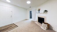Located at 1105 Quail Roost Road in Pittsburgh, Pennsylvania, this 2-bedroom, 1-bathroom residence offers 760 square feet of thoughtfully arranged single-floor living space. The open-concept layout seamlessly connects the living room and kitchen, creating a functional and inviting common area. The living room features neutral carpet flooring, white walls, and a tile-surround fireplace with a white mantel, adding a classic focal point to the space. A glass door provides access to an exterior area, allowing natural light to filter in. The kitchen is equipped with stainless steel appliances, including a refrigerator, range, and microwave, complemented by white cabinetry, dark countertops, and a peninsula with a built-in sink — ideal for both cooking and casual dining. Dark hardwood-style flooring grounds the kitchen area. The primary bedroom spans 170 square feet and includes carpeted flooring, a window with natural light, and access to a spacious walk-in closet outfitted with wire shelving and hanging rods. The second bedroom is similarly carpeted and windowed. The full bathroom features a wide vanity with white cabinetry, a tub/shower combination, and rich dark hardwood-style flooring, delivering a clean and practical finish throughout.