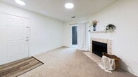 Located at 1105 Quail Roost Road in Pittsburgh, Pennsylvania, this 2-bedroom, 1-bathroom residence offers 760 square feet of thoughtfully arranged single-floor living space. The open-concept layout seamlessly connects the living room and kitchen, creating a functional and inviting common area. The living room features neutral carpet flooring, white walls, and a tile-surround fireplace with a white mantel, adding a classic focal point to the space. A glass door provides access to an exterior area, allowing natural light to filter in. The kitchen is equipped with stainless steel appliances, including a refrigerator, range, and microwave, complemented by white cabinetry, dark countertops, and a peninsula with a built-in sink — ideal for both cooking and casual dining. Dark hardwood-style flooring grounds the kitchen area. The primary bedroom spans 170 square feet and includes carpeted flooring, a window with natural light, and access to a spacious walk-in closet outfitted with wire shelving and hanging rods. The second bedroom is similarly carpeted and windowed. The full bathroom features a wide vanity with white cabinetry, a tub/shower combination, and rich dark hardwood-style flooring, delivering a clean and practical finish throughout.