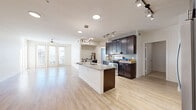 Located in San Antonio's 78256 zip code, this one-bedroom, one-bathroom residence offers a thoughtfully designed single-floor layout with a bright, open-concept living and kitchen area. Light wood-look flooring flows throughout the main living spaces, complementing the clean white walls and creating an airy, modern aesthetic.

The kitchen is a standout feature, boasting rich dark espresso cabinetry with brushed nickel hardware, granite countertops, a mosaic tile backsplash, stainless steel appliances including a gas range, and a central island with an undermount sink — ideal for both cooking and entertaining. Track lighting adds a contemporary touch overhead.

The expansive living area is bathed in natural light, with French doors opening to outdoor views and a ceiling fan providing comfortable airflow. A second living space offers additional flexibility for a dining area or home office.

The bedroom features plush carpeting, a ceiling fan, and windows with natural light, accompanied by a dedicated walk-in closet with built-in shelving and hanging rods. The full bathroom mirrors the kitchen's design language with dark cabinetry, granite countertops, and tile flooring. A dedicated laundry room with full-size washer and dryer hookups adds everyday convenience, completing this well-appointed residence.