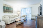 Located at 4715 Sheboygan Ave in Madison, WI, this 2-bedroom, 1-bathroom residence offers a practical and comfortable single-floor layout. The combined living and dining area serves as the heart of the space, featuring warm hardwood-style flooring and a sliding glass door framed by vertical blinds that floods the room with natural light and provides access to the outdoors. A decorative display hutch adds a touch of character and helps define the transition between the living and dining areas. The dining space is accented by tasteful wall art, creating an inviting atmosphere for everyday meals. The kitchen is efficiently designed with white cabinetry, light countertops, and stainless steel appliances including a refrigerator, electric range, and over-the-range microwave. Both bedrooms are carpeted and well-lit by natural light through sizable windows. The primary bedroom offers ample space and includes closet storage. The secondary bedroom features hardwood-style flooring and a decorative mirror accent wall. The bathroom is clean and simply appointed with wood-toned flooring and access from the hallway. Throughout the space, a neutral white and gray color palette creates a cohesive, calm aesthetic.