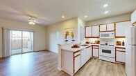 Located at 14416 McArt Rd in Victorville, California, this 2-bedroom, 2-bathroom single-story residence offers a practical and comfortable layout. The open kitchen is well-appointed with white cabinetry accented by warm wood trim, a peninsula with countertop seating, recessed lighting, and a full suite of white appliances including a refrigerator, range, microwave, and dishwasher. It flows naturally into the dining and living areas, creating a cohesive common space brightened by natural light and ceiling fans throughout. The primary bedroom features durable wood-look flooring, a warm terracotta accent wall, and sliding glass doors that open directly onto a private patio with outdoor views — an inviting extension of the living space. The second bedroom is finished with plush carpet and a ceiling fan, offering a cozy and well-lit retreat with a large window. Both bathrooms are finished with wood-look tile flooring and include a tub-shower combination with glass sliding doors, vanity with under-sink storage, and bright overhead lighting. Additional highlights include four closets, an in-unit laundry area, and a dedicated patio space. The overall ambiance is clean, neutral, and move-in ready.