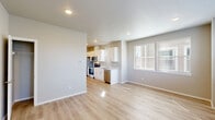 Located at 7995 NE Quatama St in Hillsboro, Oregon, this single-floor, three-bedroom, two-bathroom home offers a clean, modern design with a bright and functional layout. The open-concept living and kitchen area serves as the heart of the home, featuring light wood laminate flooring, recessed lighting, and neutral gray walls that create a fresh, contemporary atmosphere. The kitchen is well-appointed with white shaker-style cabinetry, stainless steel appliances including a refrigerator, range, microwave, and dishwasher, and light-toned countertops. A window in the adjoining living area lets in natural light, enhancing the open feel of the space. The three bedrooms are carpeted for comfort and each features windows that bring in natural light with outdoor views. One bedroom includes a private door leading to an outdoor area, adding a notable bonus. The two bathrooms are finished with white cabinetry, undermount sinks, white quartz-style countertops, and chrome fixtures. One bathroom features a full tub-shower combination. Throughout the home, the consistent use of soft neutral tones and clean finishes contributes to a cohesive, move-in-ready aesthetic that is both practical and inviting.