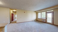 Located in Cheney, Washington, this single-floor unit offers a well-organized layout with three bedrooms, four bathrooms, and dedicated laundry. The open living area is generously proportioned, featuring plush wall-to-wall carpeting, warm neutral tones, a textured ceiling, and large windows that fill the space with natural light and views of surrounding greenery. A baseboard heating system and wall-mounted AC unit ensure year-round comfort.

The kitchen is efficiently designed with warm wood cabinetry, tile flooring, white appliances including a refrigerator, microwave, and range, and a peninsula breakfast bar that opens to the living area—ideal for both everyday use and casual entertaining.

Each bedroom is carpeted and features windows with blinds, providing ample natural light and privacy. The primary bedroom includes its own closet and ensuite access. The bathrooms are clean and functional, with tile flooring, vanities with warm wood cabinetry, large mirrors, and tub/shower combinations.

A hallway connects the bedrooms and bathrooms, finished with tile flooring and warm wood-toned doors that carry a cohesive aesthetic throughout. Three closets provide practical storage. The overall ambiance is comfortable and functional, making this a well-rounded residential unit in Cheney, WA.