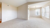 Located at 4801 S Wadsworth Blvd in Denver, CO, this 2-bedroom, 2-bathroom home offers a thoughtfully arranged single-floor layout with a warm, neutral palette throughout. The living room is a standout space, featuring vaulted ceilings, plush carpeting, and a tiled fireplace framed by a classic mantel, flanked by multiple windows that fill the room with natural light. A sliding glass door leads to a private balcony, extending the living space outdoors. The adjacent dining area is defined by a pendant light fixture and seamlessly connects to the galley-style kitchen, which is outfitted with warm oak cabinetry, granite-toned countertops, hardwood flooring, and stainless steel appliances. Both bedrooms are carpeted and include ceiling fans and walk-in closets with built-in shelving. The primary bedroom is generously sized with its own dedicated bathroom featuring a dual-sink vanity with wood cabinetry and stone-look countertops. The second bathroom offers a full tub-shower combination with tile surround and a wood-cabinet vanity. Additional highlights include a hallway, four closets for ample storage, and a dedicated laundry area, making this home as functional as it is comfortable.