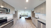 Located at 8700 Baltimore Ave in College Park, Maryland, this modern single-floor unit offers a thoughtfully designed open-concept layout that seamlessly connects the kitchen and living areas. Light wood-style flooring extends throughout, lending warmth and visual continuity to the entire space.

The fully equipped kitchen features light wood cabinetry, granite countertops, subway tile backsplash, stainless steel appliances including a refrigerator, range, microwave, and dishwasher, and an undermount sink — providing everything needed for day-to-day living. In-unit laundry is also available near the entry.

The expansive living area is bathed in natural light from a wide bank of windows, complemented by a ceiling fan overhead. A built-in counter with bar seating beneath the windows offers a casual dining or study spot, while the open floor plan provides generous room for lounging and entertaining.

Private bedrooms are well-proportioned and feature the same wood-style flooring. A dedicated study alcove with a window, desk, and chair offers a quiet workspace. The bathroom is clean and modern, finished with white subway tile in the tub-shower surround, granite countertops, wood-toned cabinetry, and wood-style flooring. The overall aesthetic is fresh, functional, and well-suited for contemporary living near the University of Maryland campus.