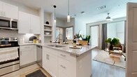 Located in Dallas, TX, this one-bedroom, one-bathroom residence offers a thoughtfully designed open-concept layout that maximizes every square foot. Light wood-style flooring flows throughout, creating a cohesive and airy feel across all rooms.

The kitchen is a standout feature, showcasing crisp white shaker cabinetry, granite countertops, a subway tile backsplash, and a full suite of stainless steel appliances, including a refrigerator with ice maker, electric range, microwave, and dishwasher. A central island with a granite surface and undermount sink doubles as a breakfast bar, with pendant lighting above adding a modern, polished touch.

The open living and dining area extends naturally from the kitchen, filled with natural light from a sliding glass door that leads to an exterior access point. The bedroom is a comfortable retreat, featuring large windows with blinds and curtains, allowing for ample natural light and privacy.

The full bathroom is well-appointed with a granite-topped vanity, white cabinetry, a large mirror, and wood-style flooring. A walk-in closet with built-in shelving and hanging rods provides generous storage. The overall ambiance is clean, contemporary, and functional, making this a refined and practical living space.