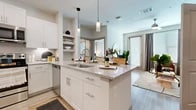 Located in Dallas, TX, this one-bedroom, one-bathroom residence offers a thoughtfully designed open-concept layout that maximizes every square foot. Light wood-style flooring flows throughout, creating a cohesive and airy feel across all rooms.

The kitchen is a standout feature, showcasing crisp white shaker cabinetry, granite countertops, a subway tile backsplash, and a full suite of stainless steel appliances, including a refrigerator with ice maker, electric range, microwave, and dishwasher. A central island with a granite surface and undermount sink doubles as a breakfast bar, with pendant lighting above adding a modern, polished touch.

The open living and dining area extends naturally from the kitchen, filled with natural light from a sliding glass door that leads to an exterior access point. The bedroom is a comfortable retreat, featuring large windows with blinds and curtains, allowing for ample natural light and privacy.

The full bathroom is well-appointed with a granite-topped vanity, white cabinetry, a large mirror, and wood-style flooring. A walk-in closet with built-in shelving and hanging rods provides generous storage. The overall ambiance is clean, contemporary, and functional, making this a refined and practical living space.