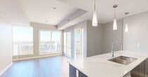 The View offers a thoughtfully designed 2-bedroom, 2-bathroom unit finished with contemporary materials and a clean, neutral palette. Light wood-look flooring runs continuously throughout the space, connecting each room seamlessly. A bright hallway with recessed lighting and modern flush doors provides an organized entry, leading to the main living area, which benefits from large floor-to-ceiling windows that frame expansive city skyline views and flood the space with natural light.

Both bedrooms feature generous windows showcasing elevated urban vistas, with light-toned walls and built-in closets offering practical storage. The primary bedroom includes a wide sliding closet and direct access to its dedicated bathroom.

The two bathrooms are finished with striking marble-effect tile on both the floors and walls, lending a polished, upscale aesthetic. One bathroom features a soaker tub with a tiled surround, while the other is equipped with a glass-enclosed walk-in shower. Both bathrooms include floating vanities with dark wood cabinetry, white undermount sinks, and large mirrors with recessed lighting.

Overall, the unit presents a modern, bright, and well-appointed layout with high-end finishes and notable city views throughout.