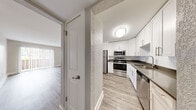 Located on W Kennedy Blvd in Tampa, Florida, this 1-bedroom, 1-bathroom residence offers a thoughtfully designed single-floor layout with modern finishes throughout. Wood-look plank flooring runs continuously across the living areas, bedroom, and kitchen, creating a cohesive and clean aesthetic. The open-concept living area is bright and airy, bathed in natural light from a sliding glass door that leads to a private balcony with outdoor views — ideal for relaxing or enjoying the Florida sunshine. The kitchen is a standout feature, outfitted with white shaker cabinetry, dark countertops, and a full suite of stainless steel appliances including a gas range, microwave, dishwasher, and refrigerator. A hallway connects the main living space to the bedroom, which is a generously sized private retreat complete with a ceiling fan, a window with natural light, and access to a dedicated closet. The bathroom features white subway tile surrounding a full soaking tub and shower combination, paired with wood-look flooring for a clean, cohesive finish. Neutral gray tones on the walls throughout the residence lend a calm, contemporary ambiance well-suited for comfortable everyday living in the heart of Tampa.