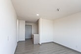 Located at 1831 Murchison Dr in El Paso, Texas, this single-floor unit offers a clean, modern layout designed for efficient and comfortable living. The kitchen is thoughtfully appointed with warm wood-toned cabinetry extending to the upper walls, a white subway tile backsplash, stainless steel appliances including a refrigerator and dishwasher, and a built-in cooktop with sink — all set against light luxury vinyl plank flooring that runs throughout the entire unit. The kitchen opens naturally into a spacious living area, creating an airy, connected feel. A small partition adds subtle definition between the entry and the main living space, which benefits from recessed lighting and a clean, neutral palette. The bedroom is a quiet retreat featuring a large window that frames sweeping city views, a wall-mounted HVAC unit, and access to a generously sized walk-in closet with a full-width hanging rod. The bathroom is finished with classic white hexagonal floor tile, a soaking tub with shower combination, brushed nickel fixtures and grab bars, and a clean, bright aesthetic throughout. The textured ceilings and crisp white walls lend the space a timeless, well-maintained character suited for a variety of lifestyles.