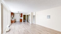 Located on Laurel Canyon Blvd in Los Angeles, CA, this single-floor unit offers a practical and efficient layout comprising a living room, kitchen, and bathroom. Light wood laminate flooring runs throughout the space, providing a cohesive and easy-to-maintain foundation across all rooms.

The living room is the largest area of the unit, offering an open and airy feel with neutral cream-colored walls and a textured ceiling. A ceiling fan provides comfort, while a large window with vertical blinds allows natural light to fill the room. A wall-mounted A/C unit and a wall heater ensure year-round climate control.

The kitchen is thoughtfully arranged in a galley-style configuration, featuring warm wood cabinetry on both upper and lower sections, a double stainless steel sink with white countertops, and a white range. The layout maximizes storage and functionality within a compact footprint.

The bathroom is clean and well-appointed, with a combination tub and shower enclosed by sliding frosted glass doors, a toilet, and a rich dark wood vanity with a white countertop. Light wood flooring continues from the main living area, tying the space together with a consistent aesthetic.

Overall, the unit presents a straightforward and functional design, ideal for those seeking a manageable, low-maintenance space in the Los Angeles area.