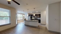 Located at 10740 N Central Expy in Dallas, Texas, this two-floor residence offers a well-designed layout with modern finishes throughout. The open-concept living and kitchen area serves as the heart of the space, featuring light wood-style flooring, recessed and pendant lighting, and a large central island topped with granite countertops. The kitchen is equipped with dark espresso cabinetry, stainless steel appliances including a refrigerator, range, and microwave, complemented by a classic subway tile backsplash. Natural light flows in through windows fitted with horizontal blinds, enhancing the bright, airy atmosphere of the main living area. The bedrooms offer plush carpeting, ceiling fans, and generous closet space, including walk-in closets with multi-tier shelving systems for ample storage. The primary bathroom features a dual-sink vanity with granite countertops, dark cabinetry, a soaking tub, a separate shower, and light wood-style flooring. A secondary bathroom provides a single vanity with matching granite countertops and dark cabinetry. Throughout the space, a consistent design palette of neutral tones, dark fixtures, and granite surfaces creates a cohesive and contemporary aesthetic.