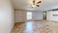 Located at 200 Logan Dr in Phenix City, Alabama, this single-story, 3-bedroom, 2-bathroom home offers a practical and well-appointed layout across its entire floor. Light wood-look flooring runs throughout the home, creating a cohesive and clean aesthetic in every room.

The open-concept kitchen and living area serves as the heart of the home. The kitchen features white cabinetry, a textured stone-tile backsplash, light countertops, a double-basin sink, and black appliances including a range, over-the-range microwave, and a full-size refrigerator. A textured ceiling and recessed lighting complete the space. The adjoining living area is bright and open, illuminated by natural light from windows and a ceiling fan with an integrated light fixture.

The three bedrooms are comfortably sized, with the primary bedroom offering a dedicated closet with wire shelving. Each bedroom includes wood-look flooring, neutral-toned walls, and windows for natural light. Both bathrooms feature wood-look flooring, vanities with mirrors and storage, and tub-shower combinations with white tile surrounds. One bathroom includes a medicine cabinet and a well-lit vanity mirror. A dedicated closet space adds additional storage utility to the home's overall floor plan.