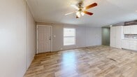 Located at 200 Logan Dr in Phenix City, Alabama, this single-story, 3-bedroom, 2-bathroom home offers a practical and well-appointed layout across its entire floor. Light wood-look flooring runs throughout the home, creating a cohesive and clean aesthetic in every room.

The open-concept kitchen and living area serves as the heart of the home. The kitchen features white cabinetry, a textured stone-tile backsplash, light countertops, a double-basin sink, and black appliances including a range, over-the-range microwave, and a full-size refrigerator. A textured ceiling and recessed lighting complete the space. The adjoining living area is bright and open, illuminated by natural light from windows and a ceiling fan with an integrated light fixture.

The three bedrooms are comfortably sized, with the primary bedroom offering a dedicated closet with wire shelving. Each bedroom includes wood-look flooring, neutral-toned walls, and windows for natural light. Both bathrooms feature wood-look flooring, vanities with mirrors and storage, and tub-shower combinations with white tile surrounds. One bathroom includes a medicine cabinet and a well-lit vanity mirror. A dedicated closet space adds additional storage utility to the home's overall floor plan.