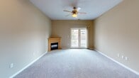 Located at 3100 S 72nd Street in Lincoln, Nebraska, this single-floor, 2-bedroom, 2-bathroom home offers a thoughtfully designed layout with comfortable living spaces throughout. The open-concept living room and kitchen area serves as the heart of the home, featuring plush carpeting, a ceiling fan, and a cozy corner fireplace with a wood-trimmed surround. French doors open to a private outdoor balcony, filling the space with natural light. The kitchen is well-equipped with warm honey-toned cabinetry, a peninsula with a double sink, tile flooring, and a stainless steel refrigerator alongside a full suite of appliances. The spacious primary bedroom features soft carpet, a ceiling fan, and a window allowing for natural light, complemented by generously sized walk-in closet with built-in shelving and hanging rods. The bathrooms are finished with hexagonal tile flooring in a neutral gray palette; the primary bath includes both a walk-in shower and a soaking tub. A second bedroom and additional closets provide ample storage throughout. Neutral warm-toned walls and consistent finishes create a cohesive and inviting ambiance across the entire home.