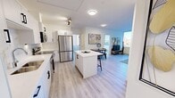 Located on the 7th floor at 529 3 Ave SW in downtown Calgary, this modern 2-bedroom unit offers a thoughtfully designed open-concept layout with light wood flooring throughout and a bright, neutral color palette. The kitchen is a standout feature, showcasing sleek white cabinetry with matte black hardware, a marble-style tile backsplash, white quartz countertops, a central island with bar seating, and a full suite of stainless steel appliances including a French door refrigerator, electric range, and built-in microwave. The kitchen flows seamlessly into the dining and living areas, creating an inviting, connected space ideal for everyday living and entertaining. The living room is filled with natural light from large windows that frame panoramic views of the Calgary skyline. The primary bedroom offers a comfortable and well-proportioned retreat with a large window overlooking downtown buildings. The second bedroom is a highlight, featuring wraparound corner windows that flood the room with natural light and provide expansive city views on multiple sides. A hallway connects the rooms efficiently, contributing to the unit's practical and functional layout. Light wood flooring, recessed and track lighting, and clean architectural lines give the space a contemporary, polished character throughout.