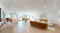 Located on North Palm Drive in the heart of Beverly Hills, this thoughtfully designed 2-bedroom, 5-bathroom residence offers a refined living experience with upscale finishes throughout. The open-concept main living area is bathed in natural light from floor-to-ceiling windows and sliding glass doors, showcasing wide-plank light oak flooring, recessed lighting, and a seamless flow between the living, dining, and kitchen spaces. The kitchen features warm natural wood cabinetry, dramatic marble slab countertops and backsplash, and a picture window framing lush greenery outside. A private glass-railed balcony extends from the main living area, offering pleasant views of the tree-lined street. The generously sized primary bedroom includes a tray ceiling, large windows, a circular accent mirror, and direct access to a luxurious en-suite bathroom appointed with marble-clad walls, a floating wood vanity with dual sinks, LED-lit mirrors, and a spacious walk-in shower with a built-in bench. The second bedroom is equally well-appointed with soft neutral tones and recessed lighting. Two dedicated closets and five bathrooms in total ensure exceptional functionality. The overall ambiance is clean, modern, and sophisticated—ideal for refined Beverly Hills living.