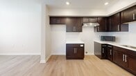 Located at 2281 E 89th St in Cleveland, OH, this single-floor, one-bedroom, one-bathroom unit offers a thoughtfully designed layout that maximizes every square foot. The open-concept kitchen and living area serves as the heart of the space, featuring rich dark espresso cabinetry that extends floor to ceiling, light-toned countertops, a subway tile backsplash, and stainless steel appliances including a dishwasher and over-the-range microwave. A peninsula adds additional counter space and storage, while recessed lighting keeps the area bright and welcoming. Light hardwood flooring runs throughout the main living areas, lending warmth and visual continuity. The bedroom is a comfortable, well-proportioned retreat with neutral walls, hardwood flooring, natural light from a window, and a double-door closet offering ample storage. The bathroom is clean and functional, featuring a tiled tub-shower combination, tile flooring in warm beige tones, and chrome fixtures. Additional conveniences include a dedicated laundry area, a utility room, and a closet for extra storage. The overall aesthetic is modern and understated, with a neutral color palette and clean finishes that create a calm, move-in-ready environment.