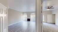 Located on White Oak Ave in the desirable Encino neighborhood of Los Angeles, this single-story home offers a well-planned layout with a cohesive neutral palette and updated finishes throughout. The spacious living room is a standout feature, showcasing light wood-style flooring, crown molding, a classic fireplace, and a row of large windows with elegant arched transoms that fill the space with abundant natural light. An adjacent area connects seamlessly to the kitchen via a raised bar counter, offering an open and functional flow. The kitchen is well-appointed with gray shaker-style cabinetry, light quartz countertops, a subway tile backsplash, and a full suite of stainless steel appliances including a gas range, microwave, and dishwasher. The bedrooms feature plush carpeting, ceiling fans, crown molding, and generous closet space, including mirrored sliding doors in one room. Each bedroom benefits from natural light through arched and grid-style windows. The bathrooms are finished with light quartz vanity countertops, large mirrors, and glass-enclosed shower and tub combinations. Overall, the home presents a clean, move-in-ready environment with classic architectural details and practical modern updates.