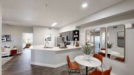 This single-floor residence offers three bedrooms and two bathrooms within a thoughtfully arranged layout. The open-concept living, dining, and kitchen area forms the heart of the home, finished with wood-style flooring and neutral tones throughout. The kitchen features dark cabinetry, stainless steel appliances, and a white peninsula with an integrated sink that provides additional prep and seating space. The adjacent dining area accommodates a round table and connects to a built-in desk nook with open shelving, adding functional versatility. The living room benefits from natural light through sliding glass doors that open to a private outdoor space. Each bedroom includes a ceiling fan and windows for ventilation and natural light. The primary bedroom connects to a walk-in closet equipped with built-in shelving and multiple hanging rods. The bathrooms feature a tub-shower combination, wood-style flooring, and dark vanity cabinetry with white countertops. A hallway links the private sleeping quarters to the main living spaces, and a dedicated entrance completes the efficient and cohesive floor plan.