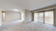 Located at 9941 Good Luck Rd in Lanham, MD, this well-appointed single-floor residence offers three bedrooms and two full bathrooms with a functional, comfortable layout. The expansive living room is a standout feature, finished with plush wall-to-wall carpeting and bathed in natural light through multiple large sliding glass doors fitted with vertical blinds — offering outdoor views and a bright, open atmosphere. The space flows naturally between a defined living area and an adjacent room, creating a versatile and generous shared space. The kitchen is efficiently designed with light wood cabinetry, dark countertops, a gas range, dishwasher, and wood-look flooring, and notably includes an in-unit washer and dryer — a convenient and practical feature. The bedrooms are comfortably sized, with the generously proportioned primary bedroom offering dedicated closet access. Neutral-toned carpeting and soft wall colors throughout lend the bedrooms a calm, restful quality. Both bathrooms feature wood-look flooring, warm wood vanity cabinetry, white tile surrounds, and clean, functional fixtures. A hallway connects the rooms seamlessly, and a dedicated closet provides additional storage. The overall design is neutral, clean, and move-in ready.