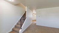 Located in Mount Joy, PA, this two-story home offers a practical and comfortable layout across two well-proportioned floors. The main level features warm hardwood-style flooring throughout the combined living area and kitchen. The kitchen is equipped with honey-toned oak cabinetry, granite-style countertops, black appliances including a range, dishwasher, and refrigerator, as well as a stacked washer and dryer unit conveniently housed in the same space. A ceiling fan with light fixture adds comfort to the living area, which also benefits from a baseboard heating system. A half bath on the main floor includes oak overhead cabinetry for additional storage. The staircase, accented with a decorative wrought-iron railing, leads to the upper level where both bedrooms are situated. Each bedroom features neutral carpet flooring, clean white walls, and ample natural light. The primary bedroom offers generous square footage with a closet, while the second bedroom includes a baseboard heater and window with exterior views. The full bathroom on the upper level is outfitted with a white tub-shower combo, white vanity, and hardwood-style flooring, maintaining a clean and bright aesthetic throughout.