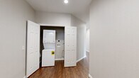 This single-floor, 3-bedroom, 2-bathroom home offers a thoughtfully designed layout that balances comfort and functionality. The open-concept kitchen and living area serves as the heart of the home, featuring rich dark cabinetry, striking bold-veined granite countertops, a breakfast bar peninsula, and black appliances, all complemented by recessed lighting and warm hardwood-style flooring. Natural light flows in through multiple windows fitted with blinds, creating a bright and welcoming atmosphere throughout.

The spacious primary bedroom is notably generous in size, boasting plush carpet, three large windows with outdoor views, and access to an en-suite bathroom. The primary bath is outfitted with a dual-sink vanity set in dark cabinetry with granite countertops and a large mirror. The secondary bathroom features a tiled tub-shower combination and wood-style flooring. Additional bedrooms are carpeted and receive natural light through well-placed windows.

A dedicated hallway utility area houses a stacked washer and dryer unit, offering the convenience of in-unit laundry. The home also includes a closet for additional storage. Neutral gray walls, white panel doors, and consistent flooring choices tie the entire space together with a clean, modern aesthetic.