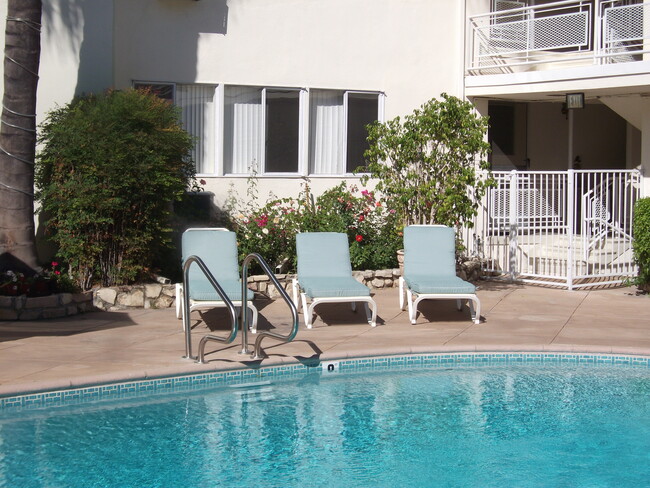 Pool Area with cushioned chaise lounges - 14065 Moorpark St