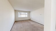 Located at 6172 S 31st St in Greenfield, Wisconsin, this two-bedroom, one-bathroom residence offers a practical and well-organized single-floor layout. The galley-style kitchen is equipped with warm wood cabinetry extending to the upper walls, a full-size refrigerator, range, and a sink with countertop workspace — all finished with neutral tile flooring that keeps the area clean and functional.

The living area features wall-to-wall carpeting and a large window that allows natural light to brighten the space, creating a comfortable and open atmosphere. Both bedrooms are carpeted and feature windows with blinds that provide exterior views and natural light. The primary bedroom includes a mirrored sliding-door closet with built-in shelving, offering notable storage capacity. An additional walk-in closet with adjustable shelving on both sides provides generous organizational space.

The full bathroom includes a tiled tub-and-shower combination, toilet, and tile flooring. A connecting hallway ties the rooms together efficiently. Throughout the residence, neutral wall tones, dark wood door accents, and consistent carpeting create a cohesive and understated aesthetic suited for everyday living.