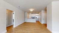 This single-story, 2-bedroom, 2-bathroom home offers a thoughtfully designed open-concept layout that maximizes its functional footprint. Light wood-tone flooring runs continuously throughout the home, creating a cohesive and airy feel.

The combined kitchen and living area serves as the heart of the home. The kitchen features white cabinetry, granite countertops, subway tile backsplash, stainless steel appliances, and a peninsula with elegant gold pendant lighting overhead. Built-in open shelving provides both storage and display space between the kitchen and living areas. The spacious living room receives ample natural light through a large picture window and is finished with a ceiling fan.

The primary bedroom is generously sized, equipped with a ceiling fan, a window with outdoor views, and direct access to an en-suite bathroom. Both bathrooms are appointed with striking marble-look tile surrounds in the tub-shower combinations, white cabinetry, granite countertops, and warm metallic fixtures in gold and brushed nickel tones. The wood-look flooring continues into the bathrooms, maintaining design consistency.

The second bedroom is bright and comfortable, featuring a window with natural views. The hallway connects all rooms efficiently, and the overall neutral color palette of soft whites and warm greiges lends the home a clean, modern ambiance throughout.