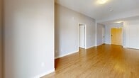 Located at 208 Woolwich St S in Breslau, Ontario, this well-appointed 2-bedroom, 2-bathroom unit offers a thoughtfully designed single-floor layout. Light-toned hardwood flooring runs throughout, lending a warm, cohesive feel to the space. The open-concept kitchen, dining, and living area forms the heart of the unit, anchored by a kitchen featuring rich dark-brown cabinetry, granite countertops, a subway tile backsplash, a double stainless steel sink, and a full suite of stainless steel appliances including a refrigerator, stove, microwave, and dishwasher. A breakfast bar provides additional seating and casual dining space. The living area extends toward a sliding glass door that opens onto a private balcony, offering scenic views of mature evergreen trees and the surrounding neighbourhood. Both bedrooms are generously sized with large windows that invite natural light; the primary bedroom includes ample closet space. Two full bathrooms and a dedicated in-unit laundry area add to everyday convenience. A welcoming entrance and hallway connect the spaces efficiently. With five closets throughout, storage is plentiful. The unit's neutral palette and modern finishes create a clean, contemporary ambiance throughout.
