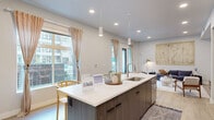 This thoughtfully designed single-floor residence showcases a clean, contemporary aesthetic throughout its open and well-connected layout. The kitchen serves as a central hub, anchored by a large island with a white quartz countertop, an undermount sink, and seating for multiple guests. Two-tone cabinetry — combining dark wood lower cabinets with crisp white upper cabinets — pairs seamlessly with a full suite of stainless steel appliances, including a side-by-side refrigerator, range, and built-in microwave. Pendant lighting above the island and recessed ceiling lights ensure ample illumination, while large windows flood the space with natural light and offer views of the surrounding neighborhood.

The open-concept living area flows directly from the kitchen, featuring light wood-look flooring, recessed lighting, and a wall-mounted flat-screen TV. A set of French doors opens to a private balcony, extending the living space outdoors. The bedroom is a tranquil retreat, carpeted for comfort and bathed in natural light from a generous window. The bathroom features a large vanity with white quartz countertop, an undermount sink, and contemporary fixtures, completing this well-appointed residence.