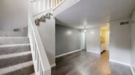 Located at 4860 Brookhaven Rd in Macon, GA, this two-story residence offers a practical and comfortable layout spread across two floors. The main level welcomes you with durable dark hardwood-style flooring, neutral gray accent walls, and a textured ceiling that adds character throughout. A staircase with a white banister connects the lower living area to the upper floor, where plush carpeting creates a softer, more relaxed atmosphere. The living room on the main level is open and versatile, with a pendant light fixture adding a modern touch. Upstairs, a generously sized second living or flex space also features carpet and a ceiling fan with integrated lighting, offering additional room for various uses. The spacious primary bedroom is carpeted and includes a ceiling fan, as well as direct access to a walk-in closet outfitted with dual shelving rods on both sides, providing ample storage. Two full bathrooms serve the home, each featuring a standard tub-shower combination with chrome fixtures. The neutral color palette, consistent flooring choices by level, and functional layout make this a well-organized and move-in ready home.