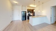 Located in the South Junction neighborhood of Memphis, Tennessee, this single-story residence offers a thoughtfully designed layout with a clean, contemporary aesthetic throughout. The open-concept living and kitchen area serves as the heart of the unit, featuring light wood-style flooring that extends across the shared spaces. The kitchen is equipped with dark espresso cabinetry, granite-style countertops, and black appliances, including a full-size refrigerator and range. A peninsula with pendant lighting overhead provides additional prep space and a natural divide between the kitchen and the expansive living area, which is bathed in a neutral palette and offers generous room for furnishings.

The bedrooms feature warm, neutral carpeting and ceiling fans with lighting, each benefiting from natural light through window blinds. At least one bedroom includes access to a spacious walk-in closet outfitted with wire shelving and hanging rods along multiple walls, offering ample storage capacity.

Two full bathrooms mirror each other in design, each featuring light wood-style flooring, a tub-shower combination with a curved chrome curtain rod, and clean white fixtures. A dedicated laundry area houses a full-size top-loading washer and dryer, adding everyday convenience to this well-appointed space.