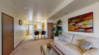 This two-floor residence offers a well-organized and functional layout across its levels. The main living area is open and inviting, featuring plush wall-to-wall carpeting, neutral-toned walls, and a front entry door flanked by windows that allow natural light to fill the space. The living room provides ample room for seating and is complemented by decorative touches including vibrant wall art and indoor greenery.

The kitchen flows seamlessly from the living area and is equipped with warm oak cabinetry, laminate countertops, tile flooring, a double stainless steel sink, a dishwasher, an electric range with overhead microwave, and a full-size refrigerator. A peninsula with bar seating connects the kitchen to the main living space, making it ideal for casual dining or entertaining.

The bedrooms are generously sized, each featuring soft carpet, ceiling fans with integrated lighting, and windows with blinds. The primary bedroom includes direct access to a private bathroom. Additional bathrooms feature tile flooring, a vanity with wood cabinetry, and a tub-shower combination. Throughout the home, consistent wood trim and warm, neutral tones create a cohesive and comfortable ambiance suited for everyday living.