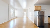 Located in the heart of Downtown Los Angeles, this 3-bedroom, 2-bathroom residence offers a well-designed single-floor layout filled with natural light. The expansive open-plan living area features light hardwood floors and crisp white walls, creating a clean, airy atmosphere. Large windows frame views of the surrounding urban cityscape, allowing sunlight to pour throughout the space.

The kitchen is outfitted with light maple cabinetry featuring glass-front upper cabinets, sleek black granite countertops, black tile flooring, and stainless steel appliances including a refrigerator and range, providing a functional contrast to the living area's warm tones.

The primary bedroom is generously sized, with multiple large windows offering sweeping city views and ample natural light. The additional bedrooms continue the hardwood flooring and feature windows that brighten each room. A dedicated closet adds convenient storage.

Both bathrooms are finished with neutral beige stone-look tile on the floors and walls. Each bathroom includes a soaking tub with a glass enclosure, a wood-toned vanity with dark countertop, and a clean, classic aesthetic. The overall ambiance of the residence is bright, open, and polished, well-suited for urban living in Downtown LA.