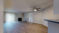 Located at 1711 S Extension Rd in Mesa, AZ, this single-floor, 2-bedroom, 2-bathroom home offers a well-organized layout designed for comfortable everyday living. The open-concept living and kitchen area serves as the heart of the home, anchored by wood-look plank flooring, a textured ceiling, and a ceiling fan with light fixture. A corner fireplace adds warmth and character to the living space, which also features built-in shelving and a sliding glass door that fills the room with natural light. The kitchen is efficiently designed with white cabinetry, dark countertops, stainless steel appliances including a refrigerator and dishwasher, a breakfast bar, and a skylight panel overhead. Both bedrooms are carpeted and equipped with ceiling fans, sliding glass doors to the outdoors, and horizontal clerestory windows that invite additional natural light. Three closets provide ample storage throughout the home. The two bathrooms are finished with wood-look tile flooring, white vanity cabinetry, and dark countertops. One bathroom includes a shower/tub combo with a window above, while the other features a vanity with a large mirror. A hallway connects the main living areas to the private bedrooms, creating a functional and cohesive flow throughout the home.