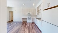 Located at 2530 Westminster Ave in Santa Ana, California, this three-bedroom, two-bathroom residence offers a well-organized single-floor layout designed for comfortable everyday living. Warm hardwood-style flooring runs consistently throughout the unit, creating a cohesive and inviting atmosphere across every room.

The kitchen is a functional highlight, featuring crisp white cabinetry with ample upper and lower storage, open display shelving, light countertops, a full suite of white appliances including a range, microwave, dishwasher, and refrigerator, as well as recessed lighting that keeps the space bright and practical. The layout flows naturally from the kitchen toward the hallways connecting the rest of the unit.

The three bedrooms are finished in neutral tones with clean white walls and vertical blinds on the windows, allowing for natural light while maintaining privacy. The primary bedroom offers a dedicated closet and direct access to the hallway. The additional bedrooms are well-proportioned and versatile.

Both bathrooms are cleanly appointed with white tub-shower combinations, chrome fixtures, and wood-style flooring. The second bathroom also includes a vanity with under-sink storage and a large mirror. A private balcony extends the living space outdoors, and two hallways provide efficient circulation throughout the unit.