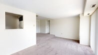 Located at 2220 High St in Cuyahoga Falls, Ohio, this 2-bedroom, 1-bathroom unit offers a practical and functional layout across a single floor. The open living area is a standout feature, filled with natural light streaming through a large floor-to-ceiling window dressed with vertical blinds, creating an airy and welcoming atmosphere. Neutral-toned carpet flows throughout the living spaces and bedrooms, lending a cohesive and clean aesthetic.

The spacious primary bedroom offers generous room for furnishings and includes a sliding-door closet with built-in shelving, providing ample storage. The second bedroom features a wide window with horizontal blinds that frames outdoor views of the surrounding neighborhood. Both bedrooms maintain a simple, neutral palette with carpeted flooring.

The kitchen is thoughtfully appointed with dark espresso cabinetry, light granite-style countertops, a double stainless steel sink, and wood-look vinyl flooring — offering a modern contrast to the rest of the unit. A hallway connects the main living areas to the bedrooms and the full bathroom, which includes a tub-shower combination, a vanity with dark cabinetry, a white countertop, and a mirrored medicine cabinet above.