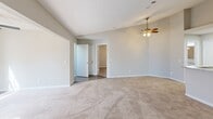 Located at 3101 Washington Ridge Way in Knoxville, TN, this 2-bedroom, 2-bathroom single-floor home offers a well-designed layout with a comfortable, functional flow. The open-concept living and kitchen area serves as the heart of the home, featuring vaulted ceilings and a ceiling fan overhead. The kitchen is equipped with white shaker-style cabinetry, granite-look countertops, black appliances including a refrigerator, range, and dishwasher, and a peninsula with an undermount sink — ideal for both cooking and casual dining. The living area extends into a spacious carpeted room highlighted by a classic fireplace with a white mantel and large windows that allow abundant natural light to fill the space. Both bedrooms are carpeted and include ceiling fans, with the primary bedroom benefiting from generous proportions and direct access to a closet and bathroom. Each bathroom features a tub-shower combination with white tile surround, granite-look vanity countertops, white cabinetry, and wood-look flooring with matte black fixtures for a contemporary touch. A dedicated utility room and two closets provide practical storage. Neutral tones throughout create a clean, move-in-ready atmosphere.