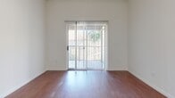 This single-floor, one-bedroom, one-bathroom residence offers a thoughtfully organized layout that maximizes functionality throughout. The interior is characterized by a clean, neutral color palette with white walls, providing a bright and airy atmosphere.

The kitchen is well-equipped with warm-toned wood cabinetry, granite-style countertops, a tile backsplash, and a full suite of black appliances including a refrigerator, range, over-the-range microwave, and dishwasher. Light ceramic tile flooring completes the space. Adjacent to the kitchen, a hallway leads to the main living area, where rich hardwood-style flooring extends throughout and a sliding glass door opens to an outdoor balcony, allowing natural light to fill the room.

The bedroom is a comfortable retreat featuring plush carpeting, a ceiling fan with light fixture, and access to two closets — including a spacious walk-in closet outfitted with wire shelving systems. The bathroom includes a full tub and shower combination with floor-to-ceiling tile surround, ceramic tile flooring, warm wood cabinetry, and chrome fixtures. A textured ceiling is a consistent architectural detail present throughout the residence. Two closets provide ample additional storage space.