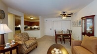 Located at 11077 W Forest Home Ave in Hales Corners, Wisconsin, this single-floor residence offers a well-organized and comfortable layout designed for easy living. The open-concept living and dining area serves as the heart of the home, featuring soft carpeting, a ceiling fan with integrated lighting, and a pass-through kitchen window that connects the spaces seamlessly. The living room provides ample space for seating arrangements and benefits from natural light through a large window. The kitchen is equipped with warm oak cabinetry, granite-style laminate countertops, a stainless steel range with overhead ventilation, and tile flooring, offering a practical and efficient cooking environment. Two bedrooms feature plush carpeting, generous closet space, and windows that allow natural light to fill each room. A hallway connects the primary bedroom to a full bathroom with a walk-in shower, oak vanity, granite-style countertop, and classic mosaic tile flooring. A second bathroom mirrors the same design aesthetic, complete with a large vanity mirror and stone-tone countertop. Throughout the residence, a neutral color palette and consistent finishes create a cohesive, calm atmosphere well-suited for comfortable, everyday living.