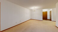 Located at 17285 W River Birch Dr in Brookfield, Wisconsin, this single-floor, 2-bedroom, 1-bathroom residence offers a functional and comfortable layout. The living area is bright and open, featuring neutral carpet, warm wood-toned baseboards, a classic chandelier, and sliding glass doors that lead to a private balcony with views of the surrounding neighborhood greenery. The generously sized primary bedroom is one of the standout features of the home, offering ample space with plush carpeting, neutral walls, and a textured ceiling. The second bedroom is equally well-appointed, with carpeted flooring and a window that brings in natural light. The galley-style kitchen is efficiently designed, offering warm oak cabinetry, white appliances including a range, refrigerator, and dishwasher, and durable wood-look flooring that adds a touch of warmth. The full bathroom is clean and straightforward, featuring tile flooring, a glass-enclosed shower stall, and classic fixtures. A dedicated closet provides additional storage. Consistent warm wood trim throughout the unit ties the spaces together for a cohesive aesthetic. This residence offers a practical and inviting layout well-suited for comfortable everyday living in the Brookfield community.