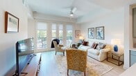 Located at 2613 Montgomery St in the heart of Savannah, GA, this thoughtfully designed one-bedroom, one-bathroom residence offers a comfortable and modern living experience across a single floor. The open-concept layout makes efficient use of space, connecting the living room, kitchen, and hallway in a cohesive flow.

The living room is a bright, welcoming retreat featuring large French doors that open onto a private balcony, flooding the space with natural light and offering views of the surrounding neighborhood. A ceiling fan adds to the comfort, while light hardwood flooring ties the room together with warmth and continuity.

The kitchen is sleek and functional, outfitted with sage-green flat-front cabinetry, stainless steel appliances including a French door refrigerator, electric range, and built-in microwave, all complemented by clean white countertops and light wood flooring. The design balances practicality with contemporary style.

The bedroom is a serene space with large windows that invite natural light, a ceiling fan, and a double closet for ample storage. The bathroom features a frameless glass walk-in shower with floor-to-ceiling white tile and matte black hardware accents, offering a spa-like aesthetic. The overall ambiance throughout the residence is clean, light, and modern.