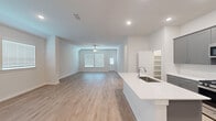 Located at 17003 Telge Road in Cypress, TX, this well-appointed single-story home offers a thoughtfully designed open-concept layout across three bedrooms and three full bathrooms. Light wood-look flooring flows consistently throughout, complementing the crisp white walls and creating a bright, cohesive aesthetic.

The heart of the home is the kitchen, featuring gray shaker-style cabinetry, a white quartz countertop island with an undermount sink, subway tile backsplash, and stainless steel appliances including a gas range, microwave, and refrigerator. An adjacent walk-in pantry provides generous storage. The kitchen opens seamlessly into the spacious living area, which is equipped with a ceiling fan and receives natural light through front-facing windows.

The generously sized primary bedroom includes vaulted ceilings and a ceiling fan, leading to a well-designed en-suite bathroom with dual sinks, gray cabinetry, quartz countertops, and a walk-in shower. A large walk-in closet with dual hanging rods and open shelving adds practical storage. Secondary bedrooms are well-proportioned with ceiling fans and natural light. A dedicated laundry room houses side-by-side washer and dryer units with overhead shelving. The attached garage features an automatic opener and an electrical panel, completing this functional and modern home.
