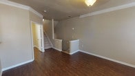 This two-story residence offers a thoughtfully designed layout spread across two floors, combining functional living spaces with quality finishes throughout. The main living area is a standout, featuring rich dark hardwood flooring, crown molding, and a granite-surround fireplace flanked by built-in shelving. Large windows and a bay window arrangement flood the space with natural light and offer views of the surrounding greenery, while a ceiling-mounted light fixture adds a decorative touch.

The kitchen is well-equipped with dark espresso cabinetry, granite countertops, stainless steel appliances, and hardwood flooring, providing a practical and attractive cooking space. A staircase with white balusters connects the two floors, opening onto an upper-level landing with wood flooring.

The bedrooms are carpeted for comfort and receive ample natural light through multiple windows, including an arched window accent in one room. Several bedrooms feature direct access to bathrooms. The bathrooms are finished with granite-topped dark vanities and hardwood floors. One bathroom includes a glass-enclosed walk-in shower with tiled walls, while others feature tub-shower combinations. A mirrored closet in one bedroom adds storage and visual depth to the space.