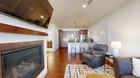 Located on Sheboygan Road in Cedarburg, Wisconsin, this well-appointed one-bedroom, one-bathroom unit offers a thoughtfully designed single-floor layout. The open-concept living and kitchen area serves as the heart of the home, featuring rich hardwood flooring throughout. The living room is anchored by a sleek fireplace with a wood mantel, large windows that invite natural light, and a ceiling fan overhead. The kitchen is a standout, outfitted with warm-toned cabinetry, granite countertops, a subway tile backsplash, stainless steel appliances including a gas range and French door refrigerator, and a peninsula with bar seating — ideal for casual dining. The bedroom offers a comfortable retreat with plush carpet, a large window with natural light, and ample closet space. The bathroom continues the home's refined aesthetic with granite countertops, rich wood cabinetry, and tile flooring. Additional conveniences include in-unit laundry, a utility room, multiple closets, and an attached garage. The neutral color palette and consistent finishes throughout give the space a cohesive and polished feel.