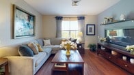 Located at 15 Princeton Dr in Hooksett, New Hampshire, this single-floor residence offers a thoughtfully designed layout that balances comfort and functionality. The living room serves as the heart of the home, featuring warm hardwood flooring, neutral toned walls, and a large window dressed with elegant curtains that frame lush outdoor greenery, filling the space with natural light and a welcoming ambiance.

The kitchen is efficiently arranged with warm wood cabinetry, granite-style countertops, and a full suite of stainless steel appliances including a refrigerator, electric range, and built-in microwave — offering a practical and clean workspace.

The bedroom is a peaceful retreat, carpeted for comfort and bathed in natural light from multiple windows that overlook verdant tree canopies. Patterned curtains add a decorative touch, complementing the calm, neutral color palette. Ample space accommodates a generous bed and additional furniture with ease.

The bathroom is clean and well-maintained, featuring tile flooring, a wood-toned vanity with a light countertop, and a full tub-shower combination. Framed wall art and fresh floral accents contribute to a polished, serene finish. Overall, this residence offers a cohesive and comfortable living environment with a consistent aesthetic throughout.