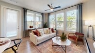 This single-story residence at 13003 FM-1488 in Magnolia, Texas, offers a thoughtfully designed layout with cohesive modern finishes throughout. Light wood-style flooring flows seamlessly across the living, kitchen, and bedroom areas, creating a warm and unified aesthetic.

The living room is a highlight of the space, featuring a bank of large windows that frame views of surrounding greenery and flood the room with natural light. A ceiling fan adds comfort, while the open, airy layout accommodates relaxed everyday living.

The kitchen is well-equipped with dark taupe cabinetry, granite countertops, a classic subway tile backsplash, and a full suite of stainless steel appliances. A peninsula with bar seating connects the kitchen to the dining area, making it ideal for both cooking and entertaining.

The bedrooms are generously sized, each with large windows and ceiling fans. The primary bedroom connects directly to a private bathroom featuring dark wood vanity cabinetry with granite counters and a tub-shower combination with full subway tile surround. A secondary bathroom mirrors similar finishes.

A dedicated hallway laundry closet with stacked washer and dryer adds everyday convenience. Overall, the space presents a clean, modern ambiance with practical functionality.